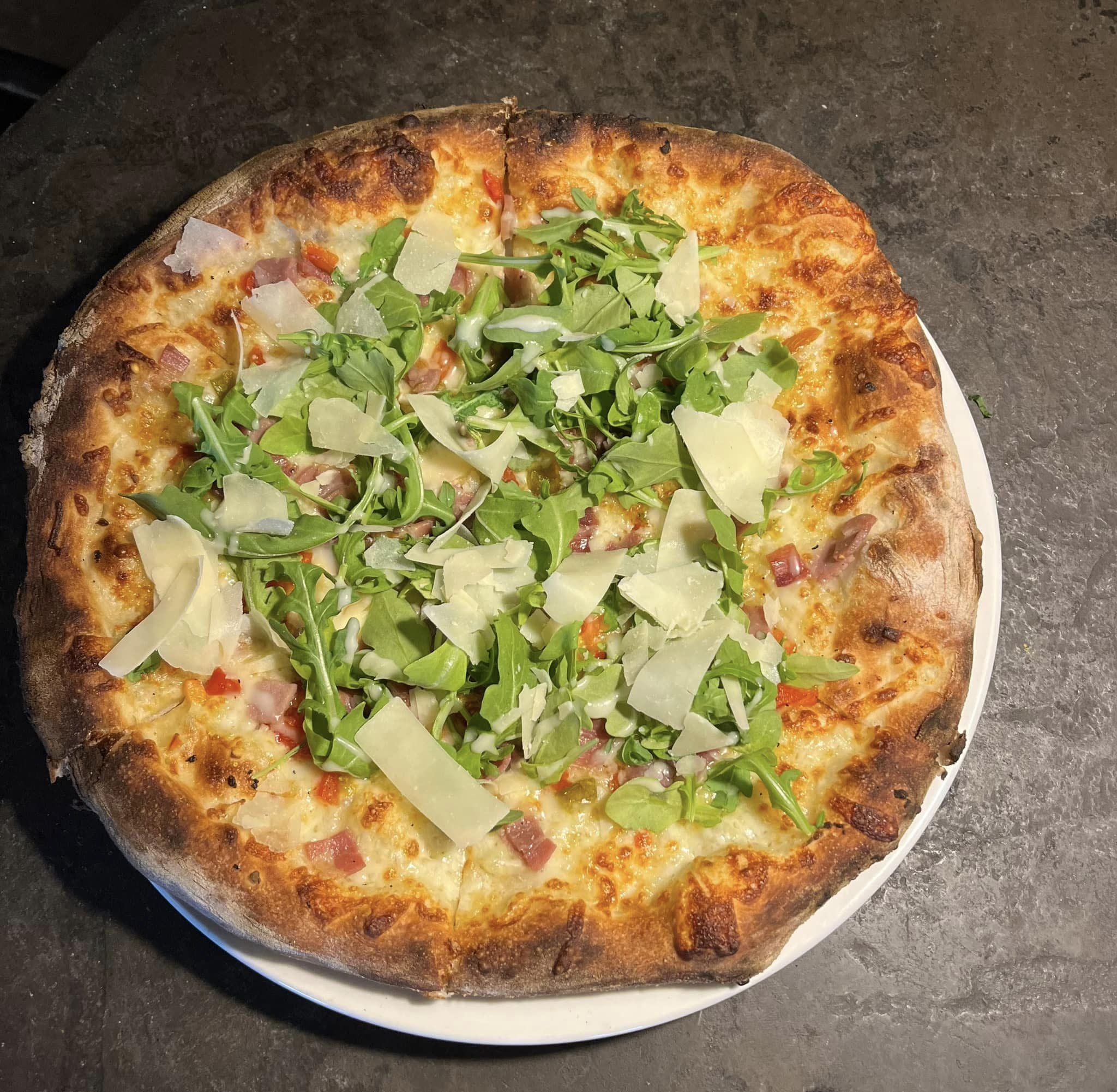 Cristo’s Wood Fired Pizza and Pasta signature dishes Wood-Fired Pizza, Chicken French, Peas and Prosciutto Alfredo, Utica Greens